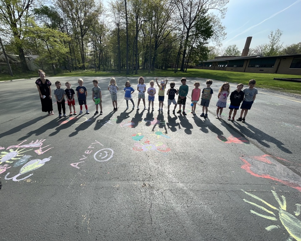 Mrs. Bragg’s Kindergarten students stand on their chalk art before heading to the outdoor classroom to learn about Red-shouldered Hawks.